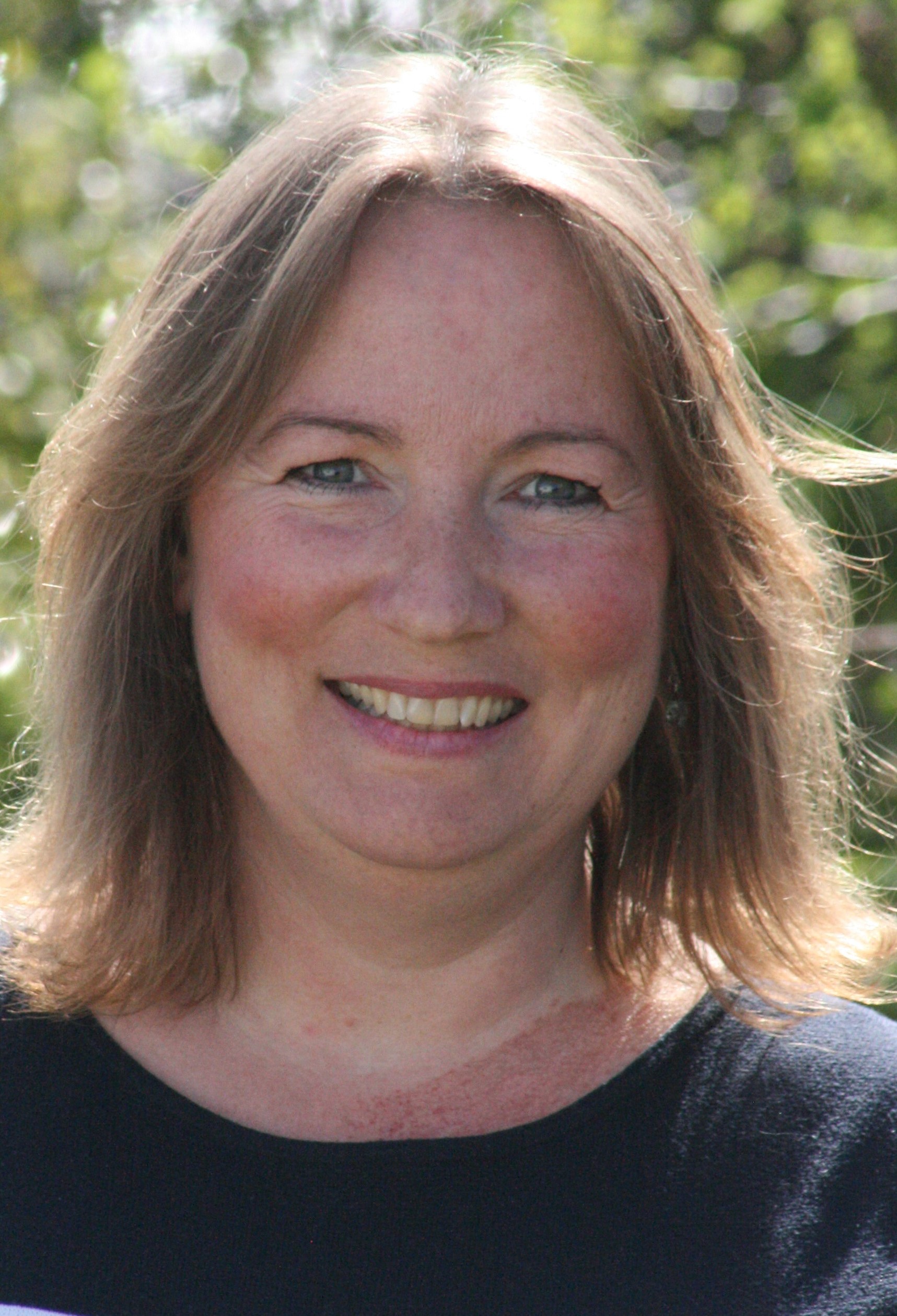 En kvinne som smiler til kameraet