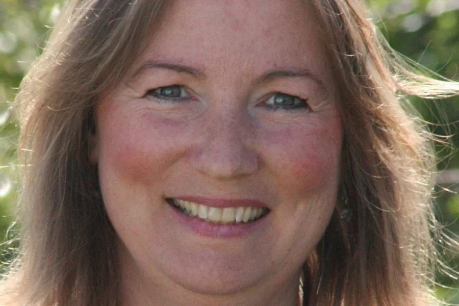 En kvinne som smiler til kameraet