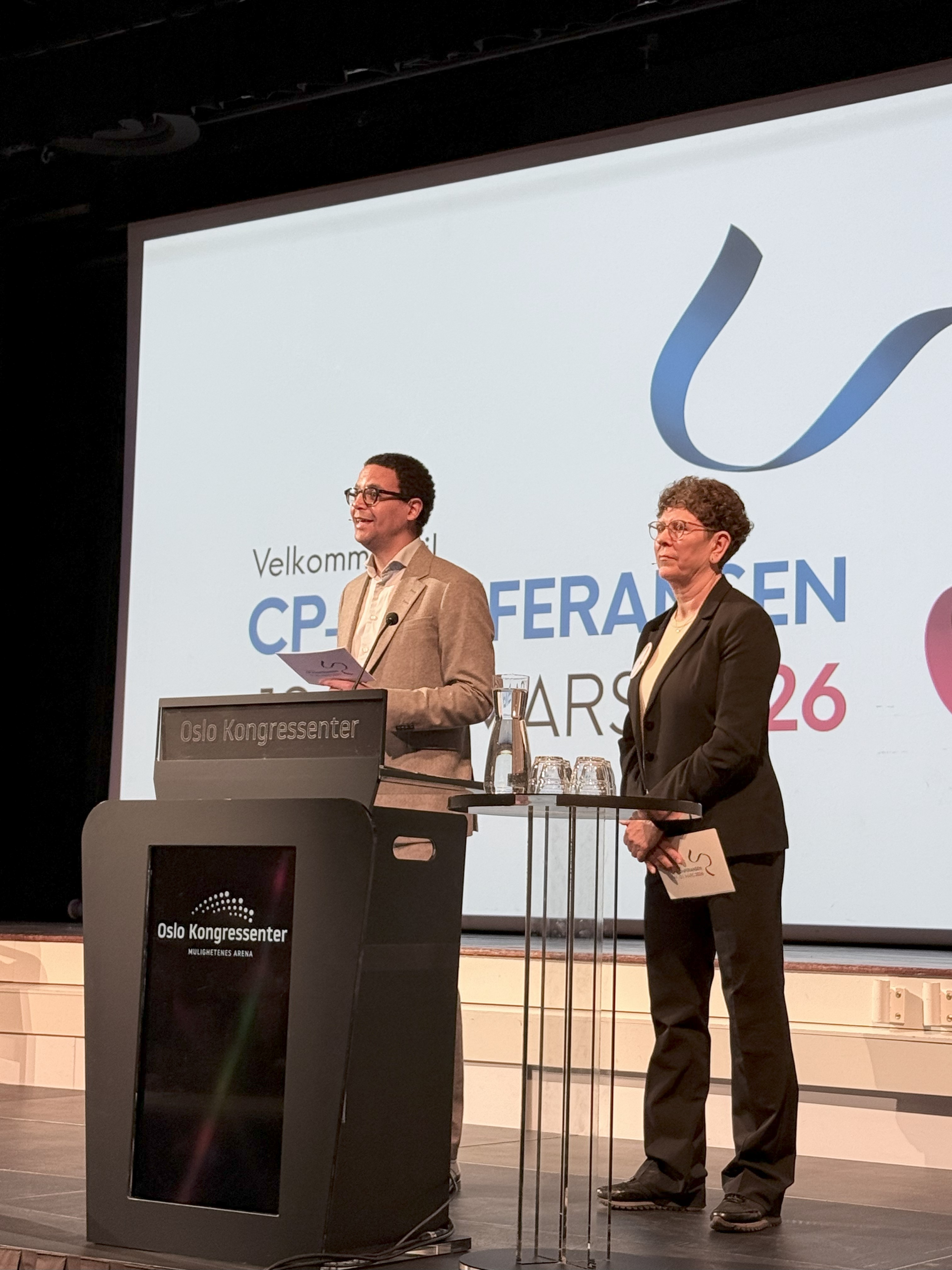 En mann som holder en tale og en kvinne som står ved siden av