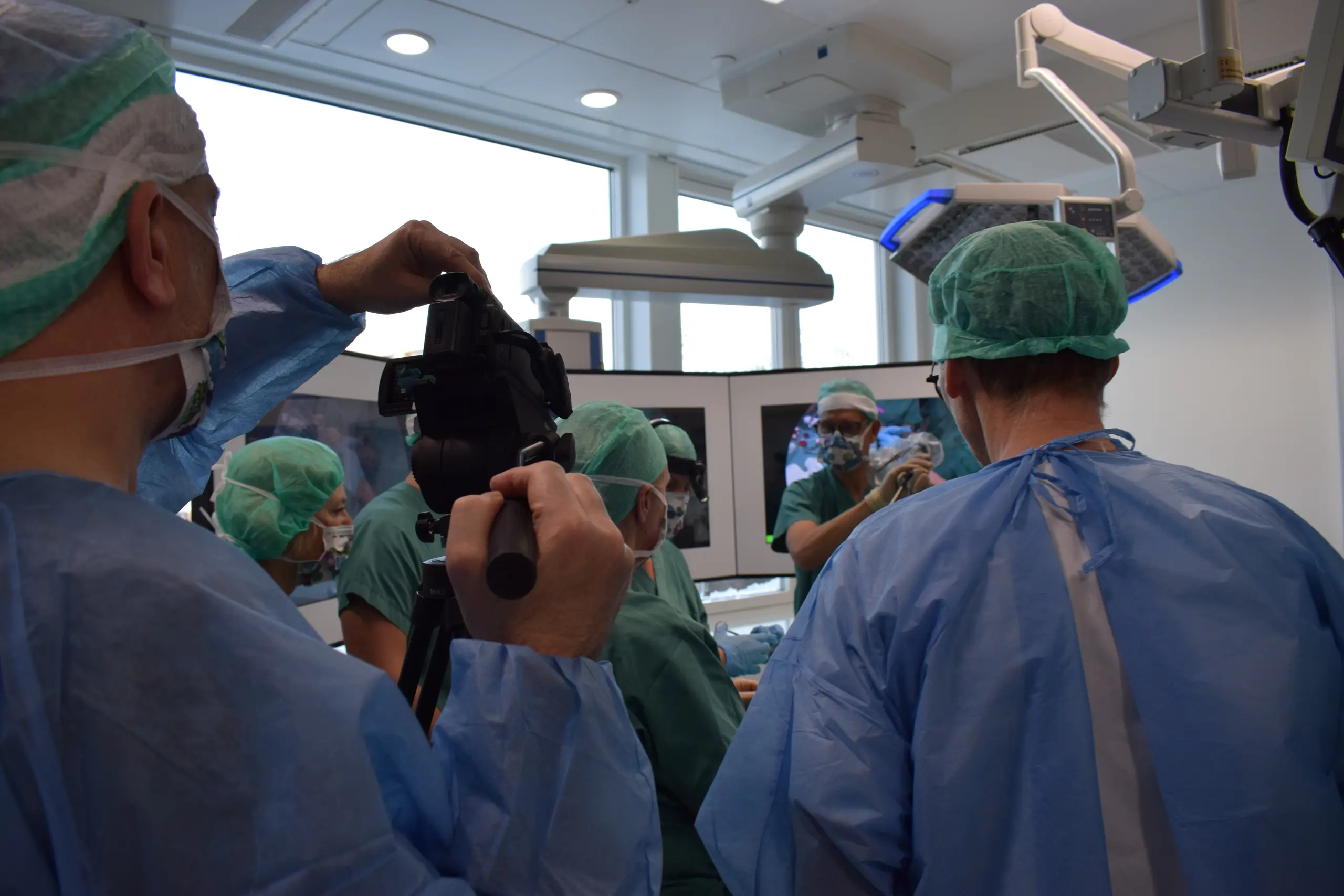 En gruppe personer kledt i blått og grønt i en operasjonssal