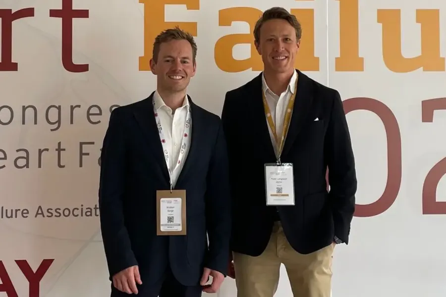 Et par menn som poserer for et bilde