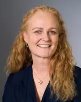 En kvinne med langt hår som smiler