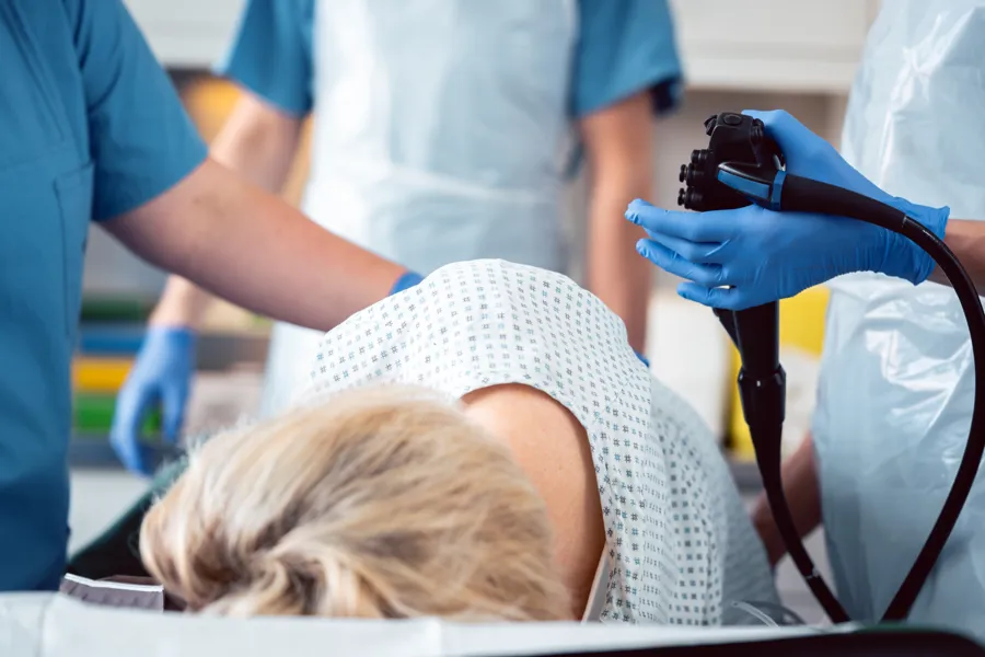 Pasient på undersøkelsesbord med tre helsearbeidere rundt