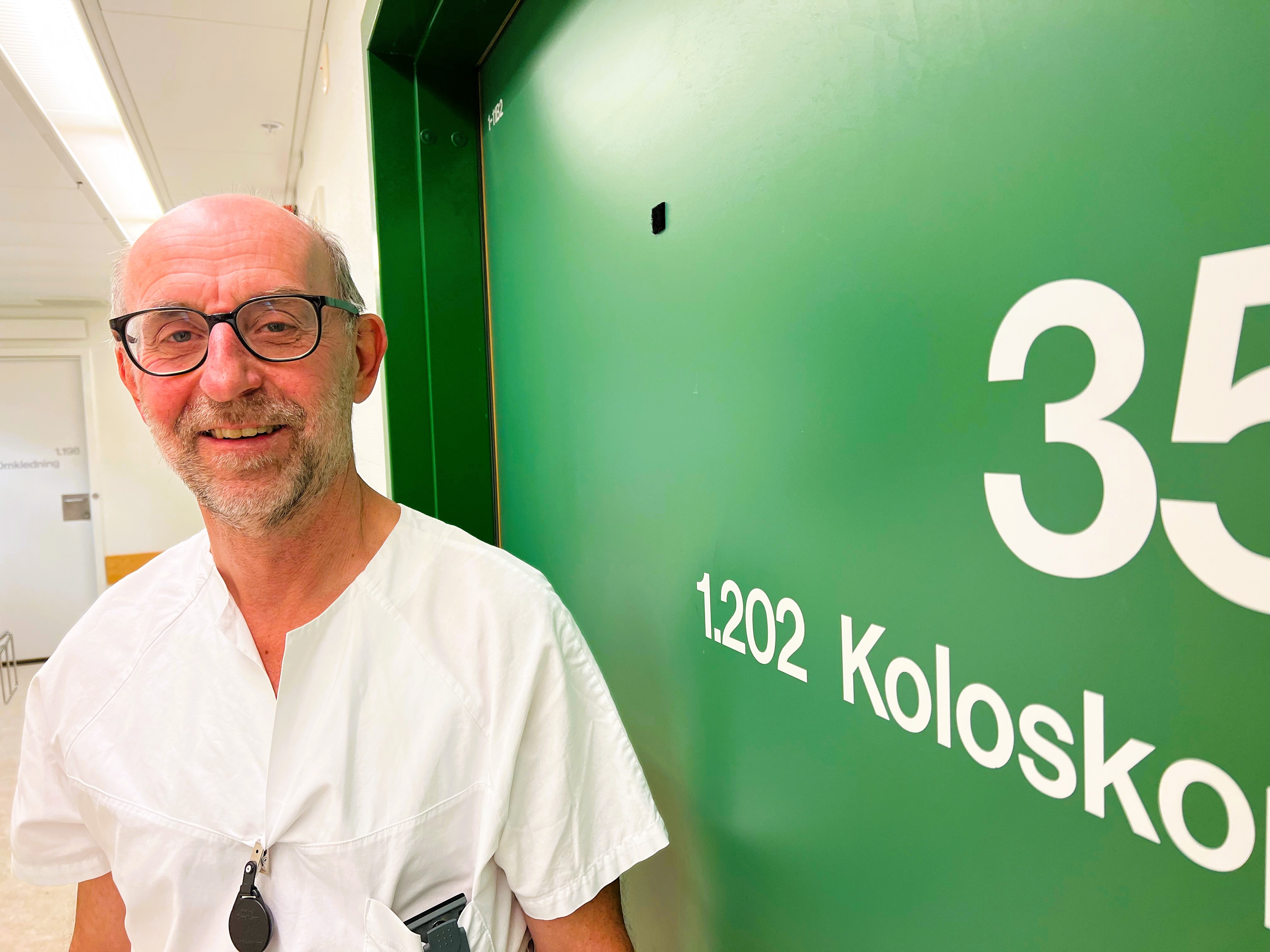 En mann som står foran en grønn tavle