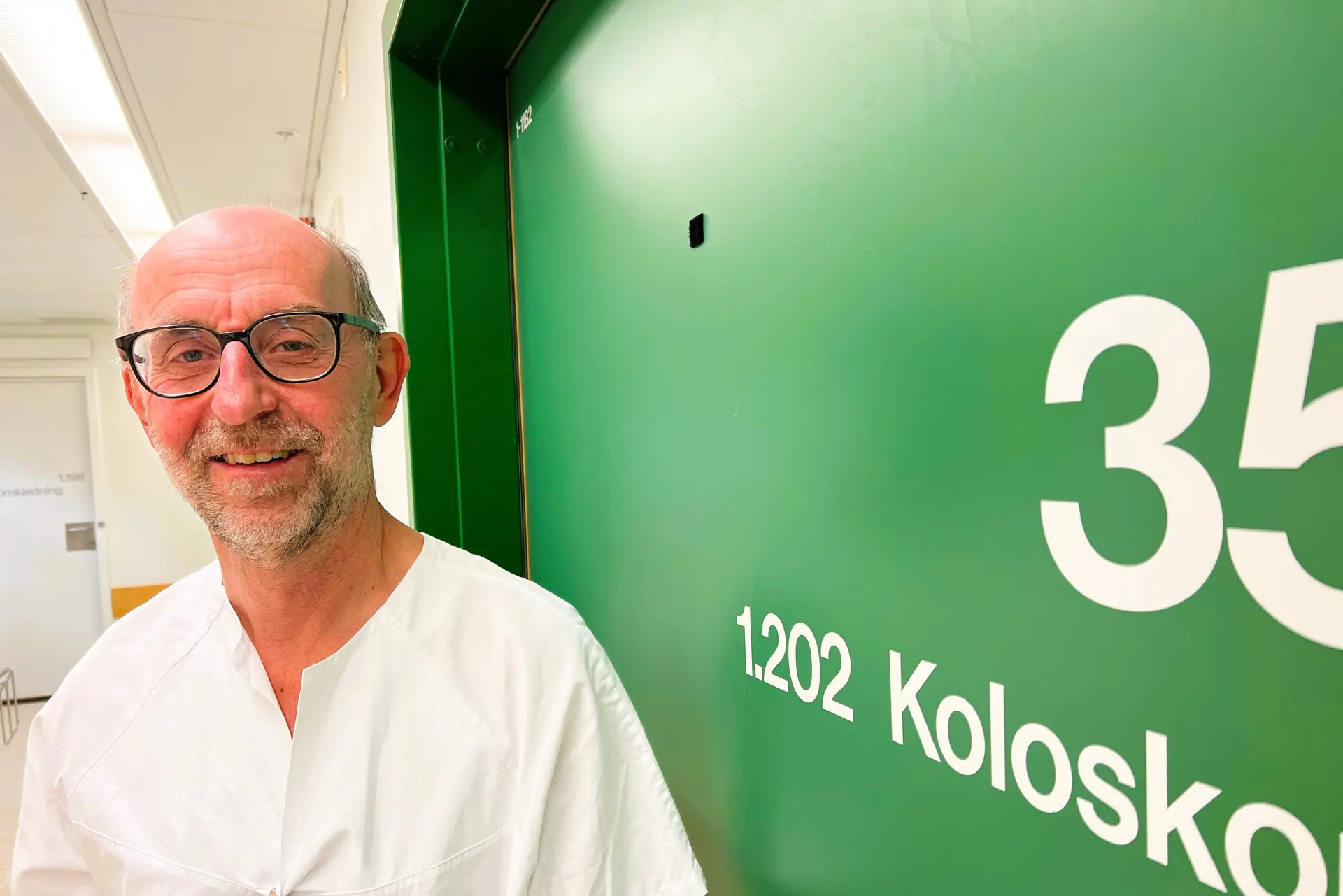 En mann som står foran en grønn tavle